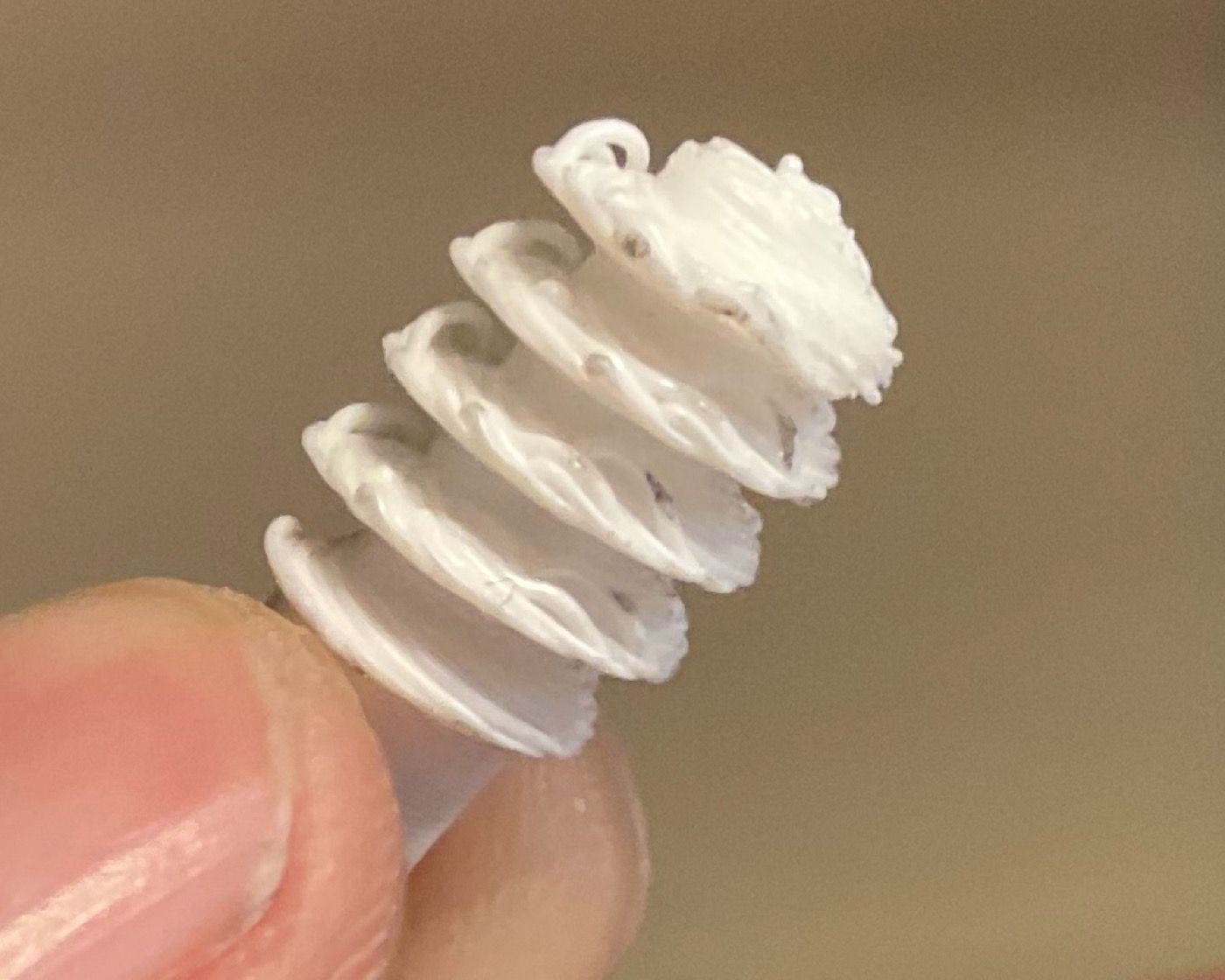 Macro shot of an early printed worm gear on a fingertip
