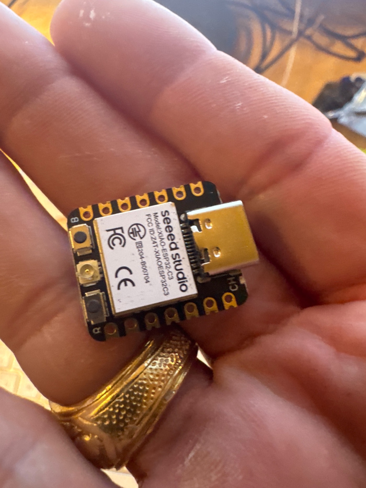 XIAO ESP32 held between fingers