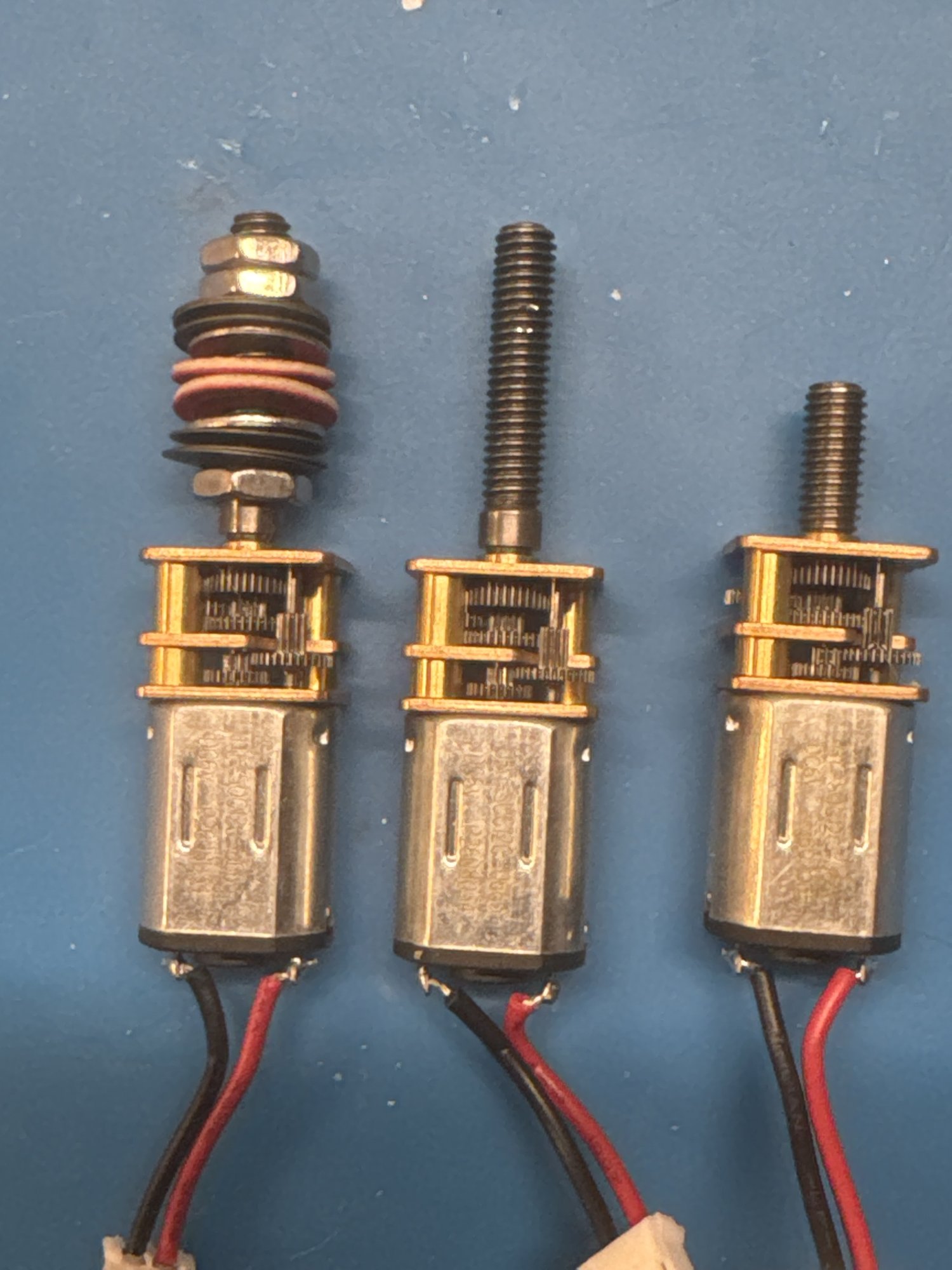 Three motors side by side: new with the clutch stack, new bare, and the original